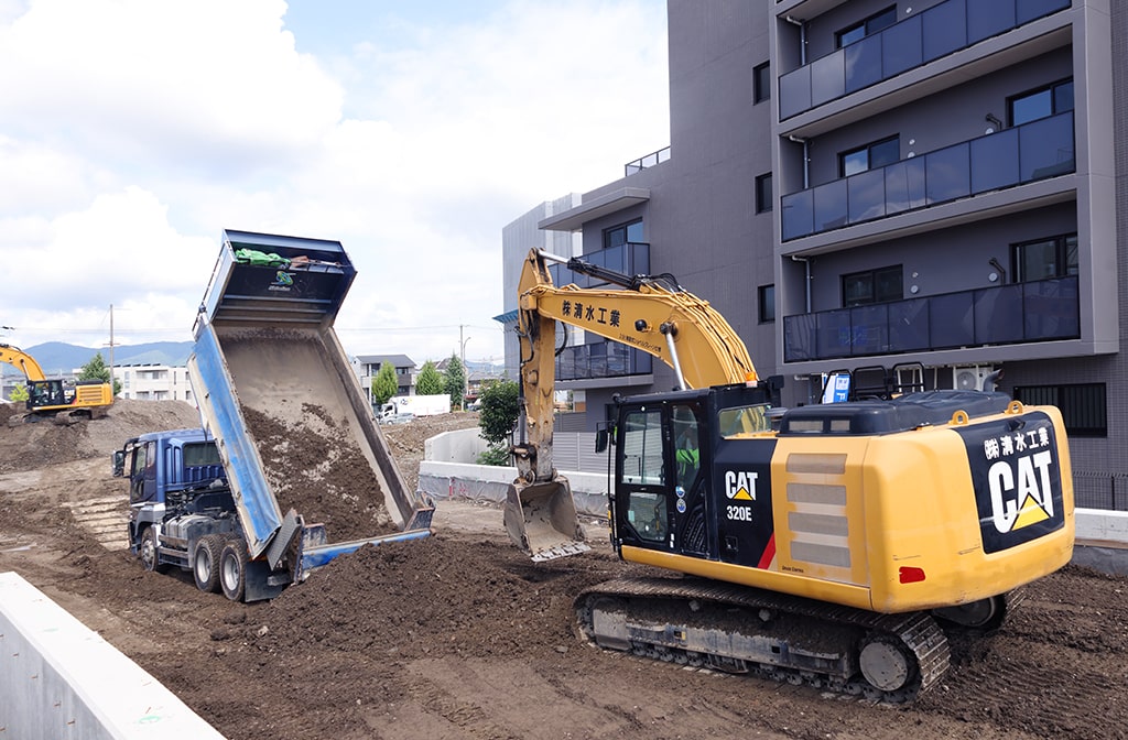 トラックの荷台から土をおろしている