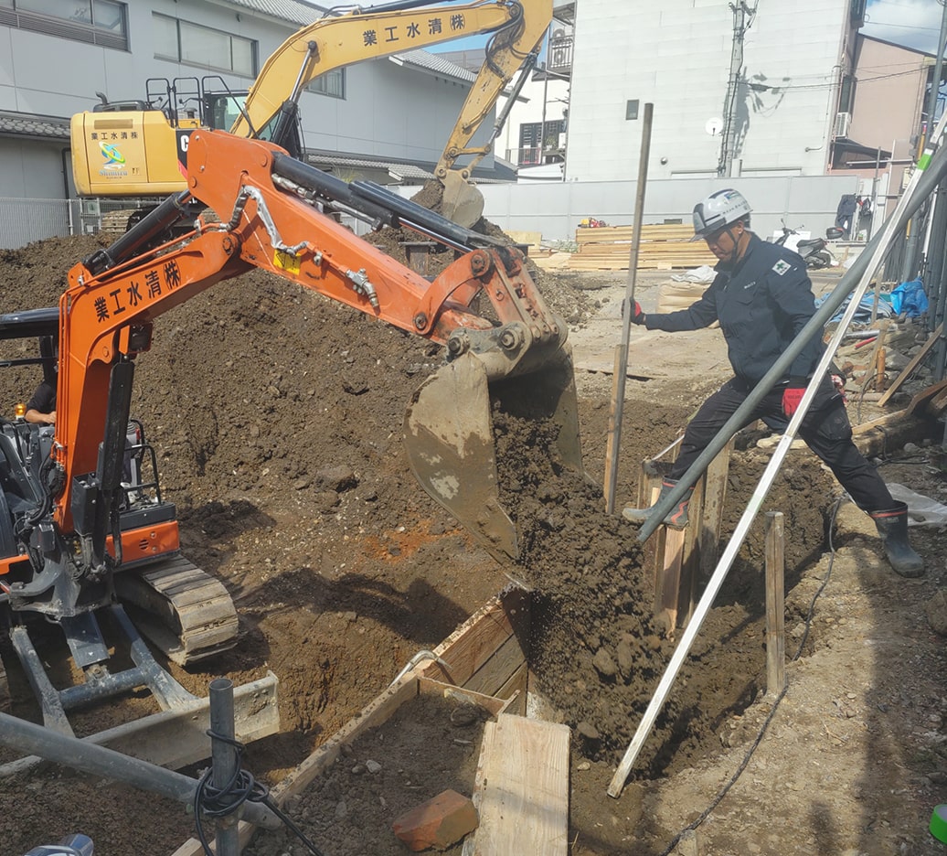 建設現場で作業員が掘削作業を行っている様子