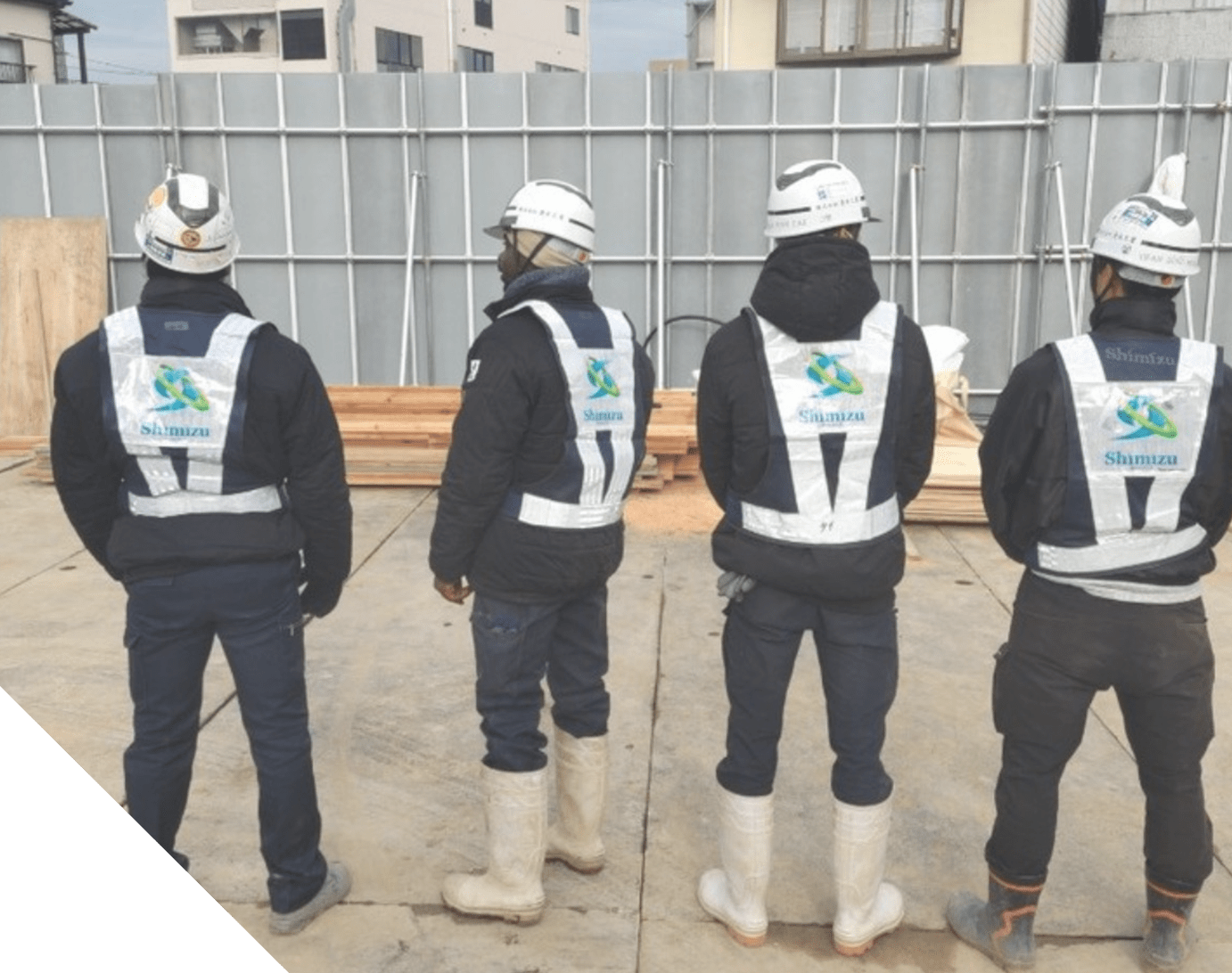 作業着を着た従業員が４人並んでいる